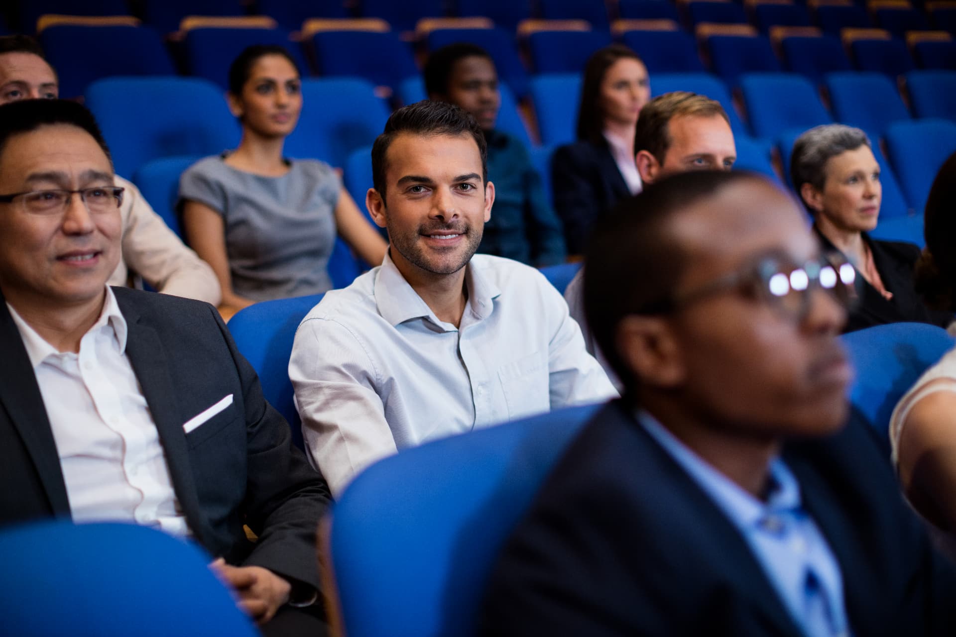 Executives seated in an auditorium during a program session