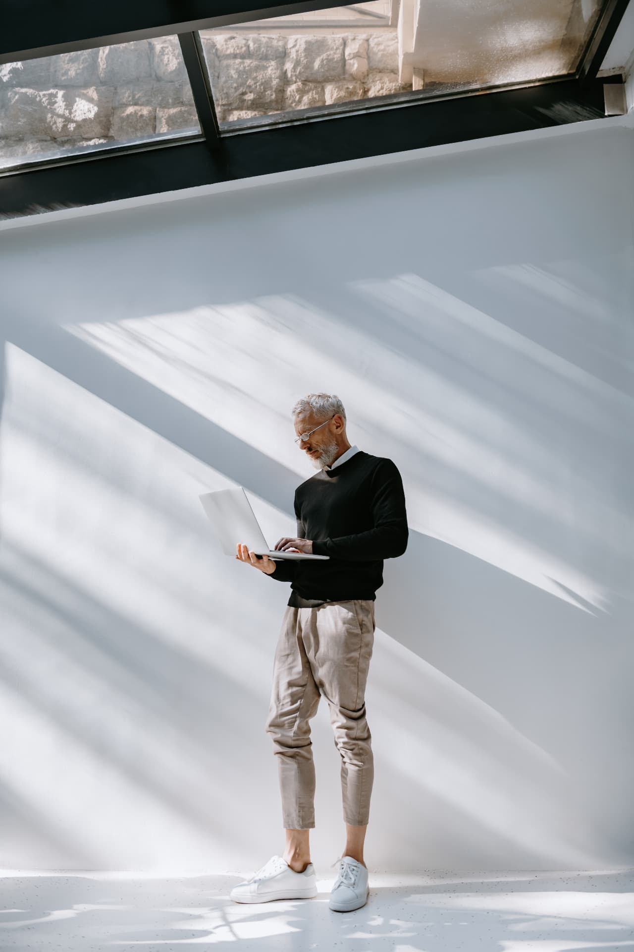 A leader working on a laptop in a light-filled modern space
