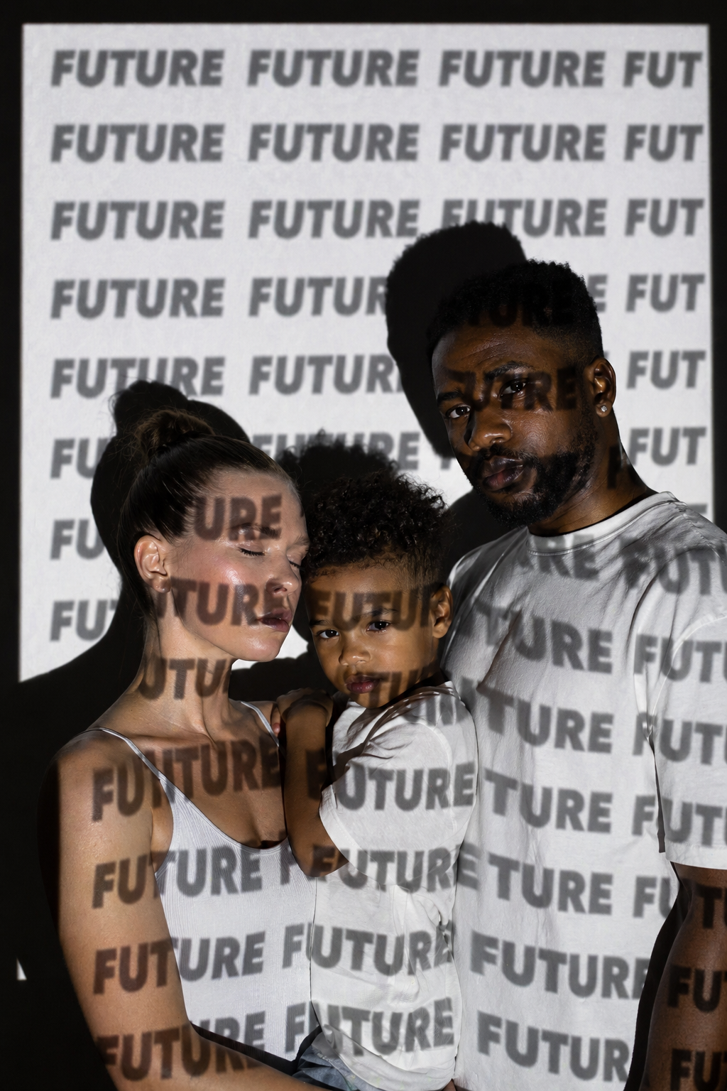 A family lit by a projected FUTURE typographic pattern